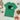 Green t-shirt with 'GB Hockey' logo on a wooden surface with Christmas decorations.